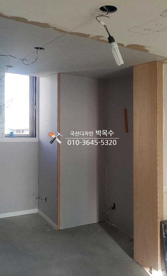회색 벽면과 목재 구조물이 보이는 시공 현장