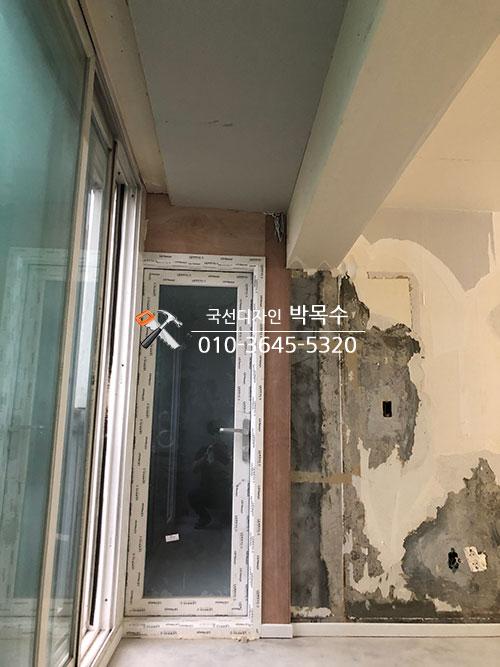 보드로 마감 중인 현관 벽면과 슬라이딩 창호