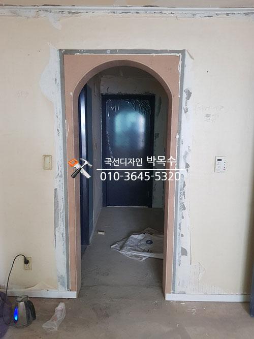 아치형 문틀과 페인트 작업 중인 복도