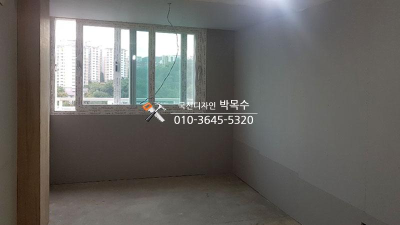 흰색 벽면 마감과 회색 하단부가 보이는 방