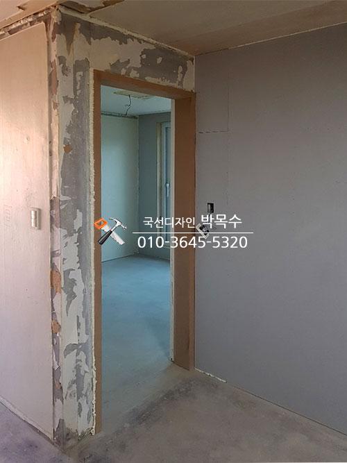 갈색 문틀과 콘크리트 바닥이 보이는 복도