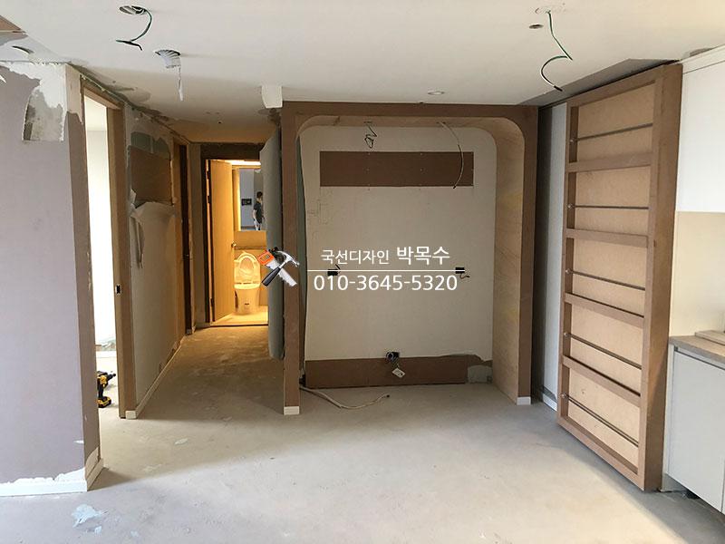 복도 공간에 목재 수납장을 설치하고 있는 과정