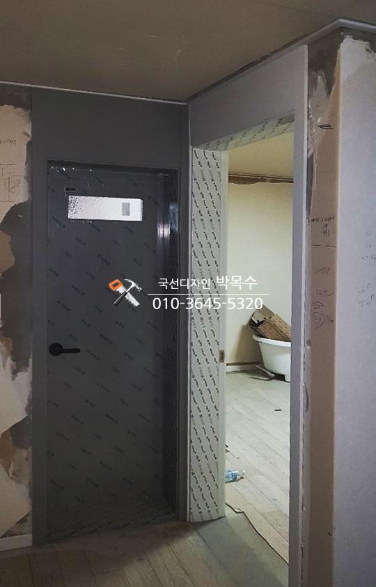 벽면 철거 후 보드로 덮인 복도 공간