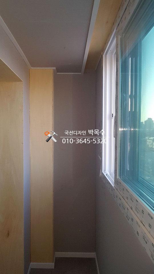 회색 벽면과 화이트 베이스보드가 만나는 복도