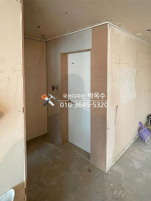 벽지가 제거된 복도에 설치된 흰색 문