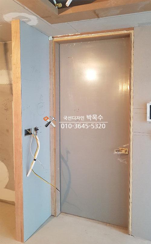 파란 보호재가 붙은 도어 문짝과 프레임