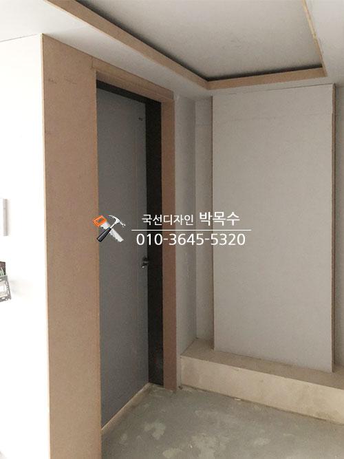 베이지색 프레임과 회색 문이 설치된 복도
