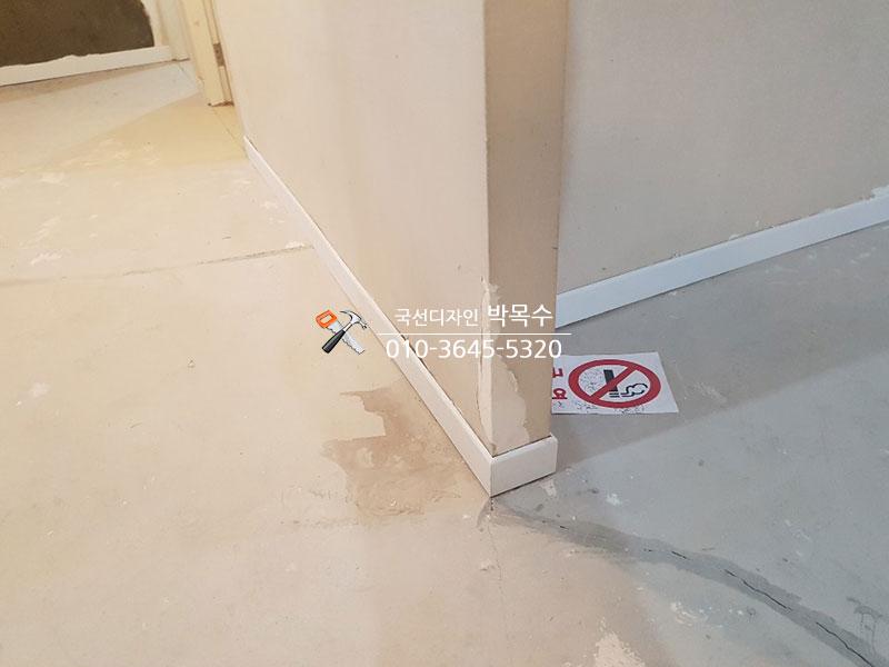 바닥과 벽면 하단부의 마감 작업이 진행 중인 모습