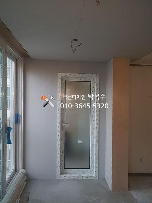 보드로 문 주변 마감을 진행 중인 모습