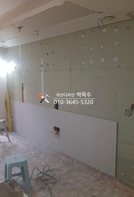 벽면 구멍과 전선이 노출된 공사 중인 실내
