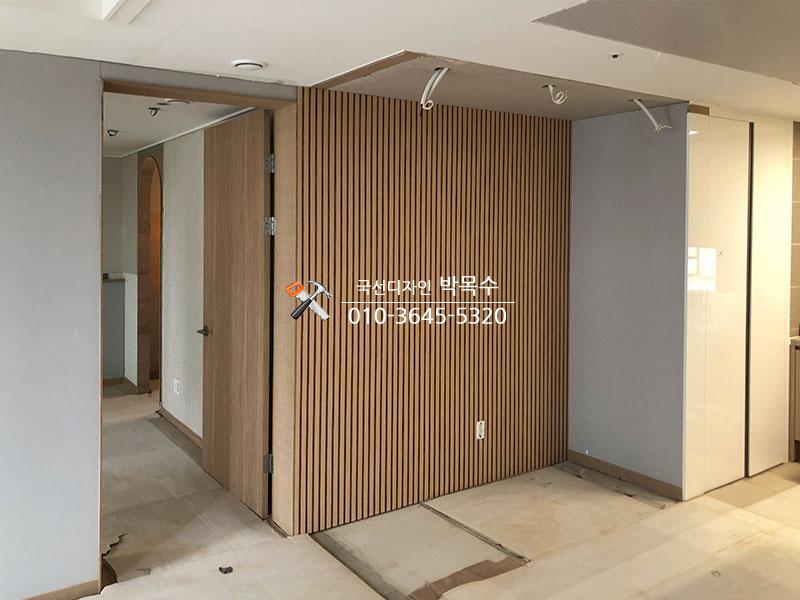 수직 나무 패널과 문틀이 배치된 복도