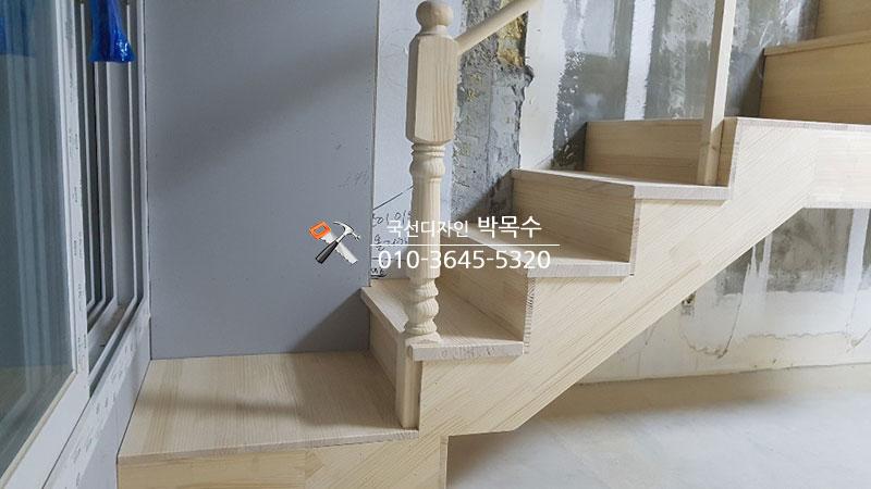 나무 계단이 설치되고 있는 복도 벽면의 모습