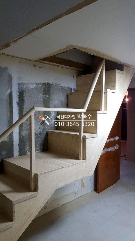 목재로 제작 중인 계단과 마감 작업 중인 벽면