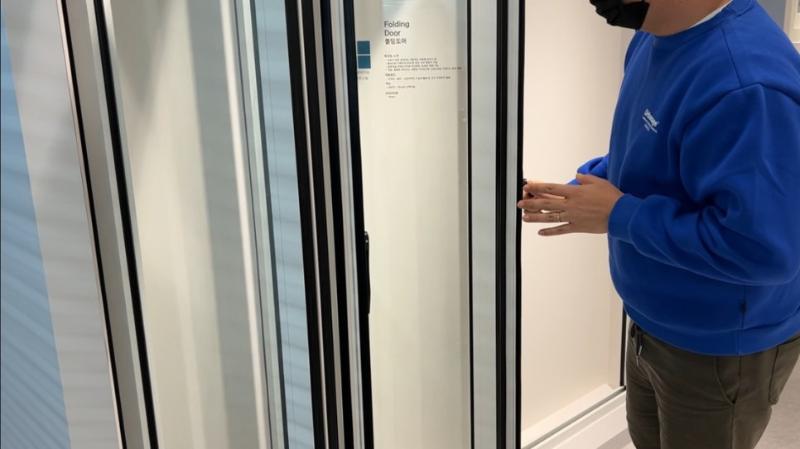 접이식 문의 손잡이 조작과 벽면 표지판