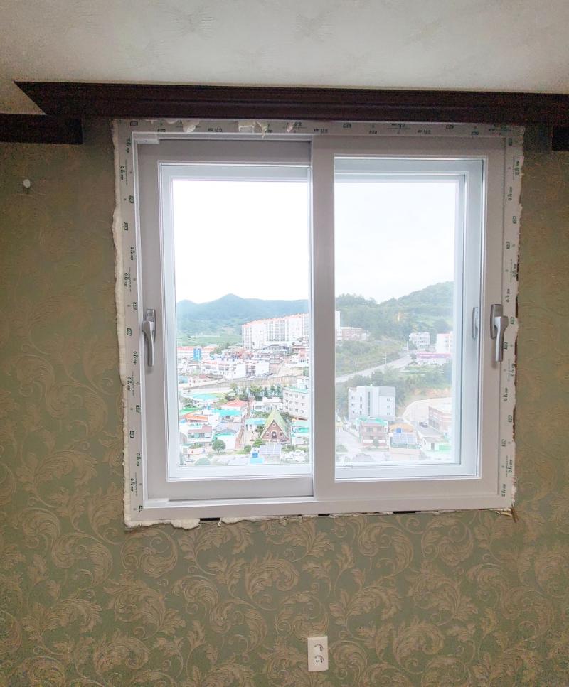 벽지 마감 벽면에 설치된 창호 유리 패널과 손잡이