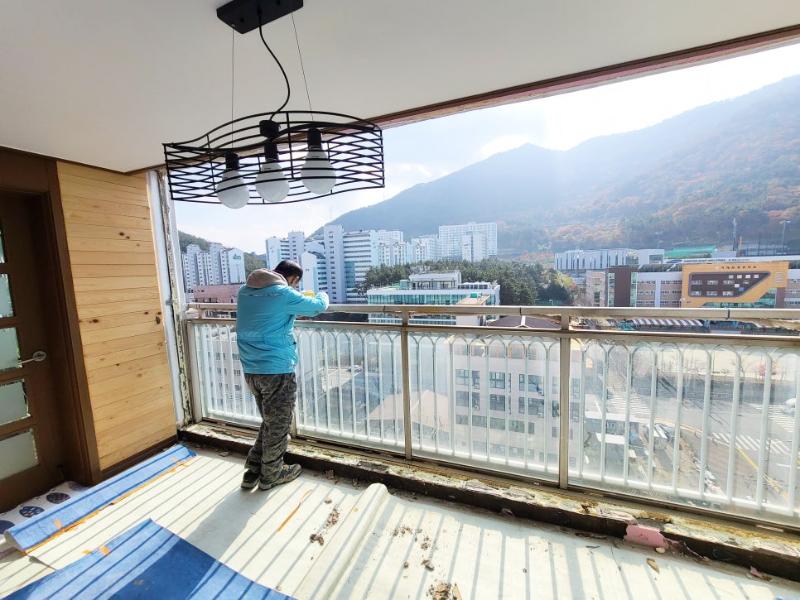 흰색 금속 난간과 창호가 맞닿은 발코니 바닥의 모습