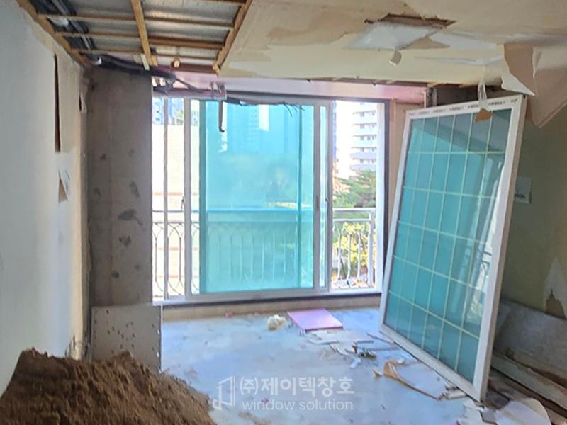 천장 구조물이 노출되고 창호 부품들이 놓인 공사 현장