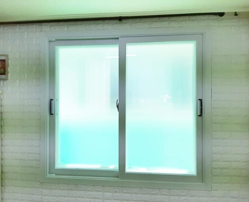 흰색 타일 벽면과 흐릿한 유리창의 근접 모습