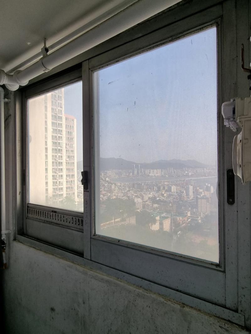 먼지가 쌓인 유리창 너머로 보이는 도시 풍경