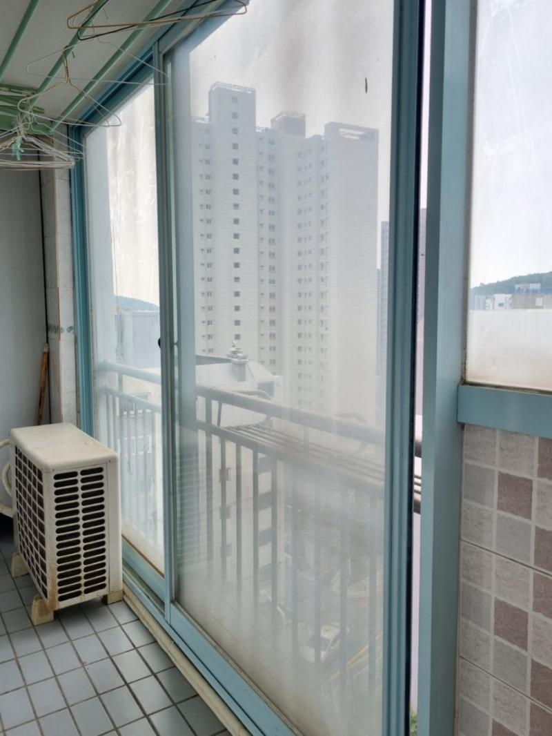 흰색 냉난방기가 배치된 공간의 파란 테두리 창호