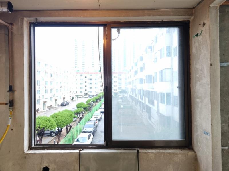 콘크리트 벽면과 설치 중인 슬라이딩 유리문