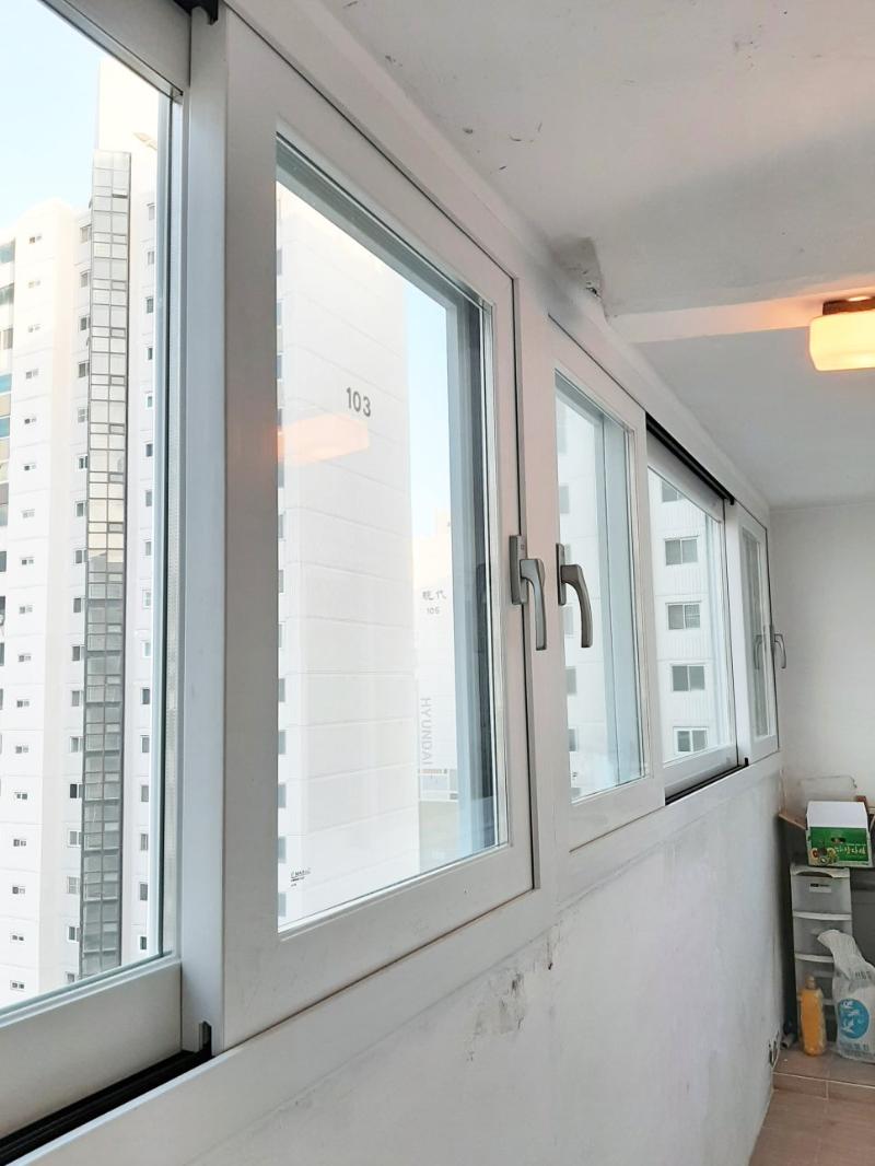 건물 외벽과 맞닿은 흰색 창호 프레임