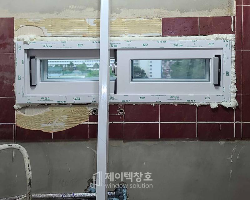 벽돌 벽면에 보조재와 함께 설치 중인 창호