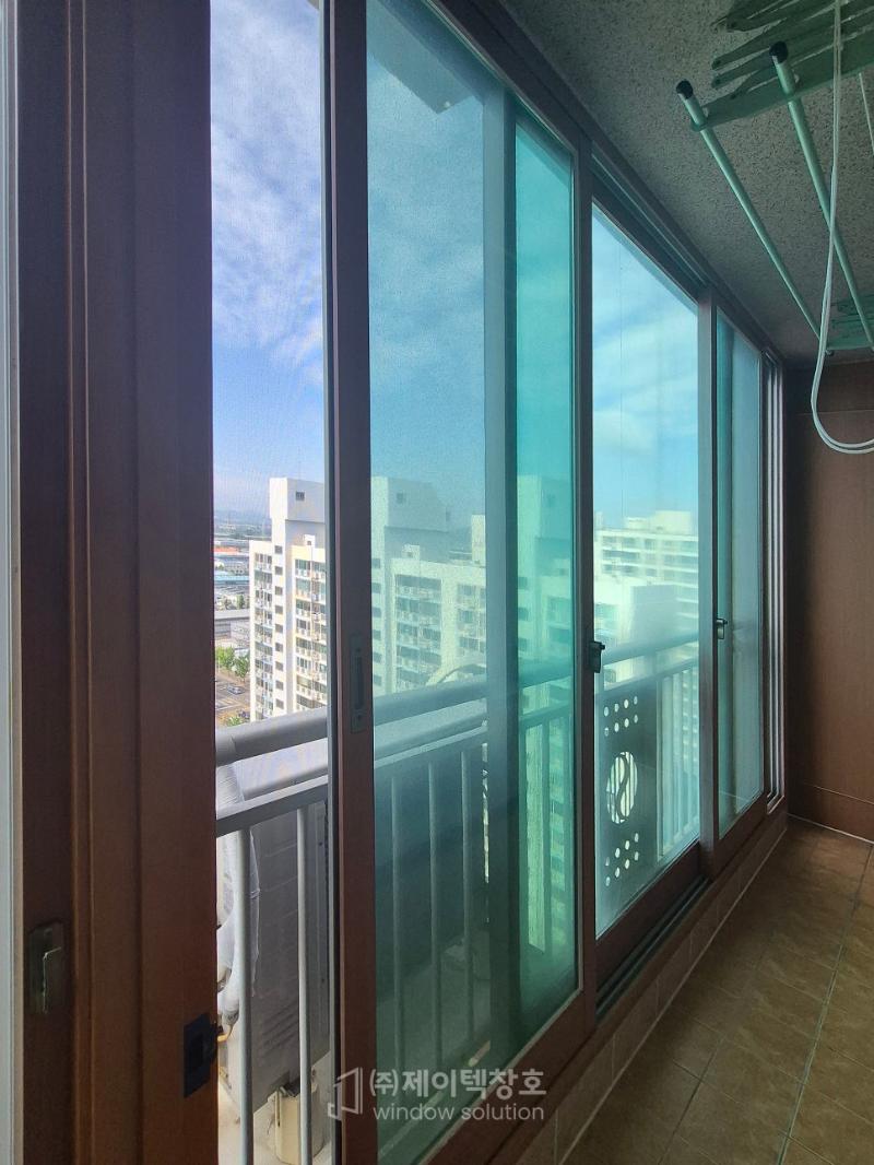타일 바닥 위로 설치된 유리창호와 외부 풍경