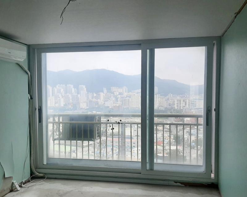 파란색 페인트 벽면과 전선이 노출된 창호 설치 현장