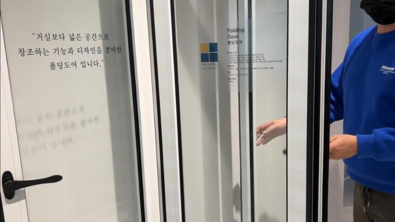 설명 표지판이 부착된 편의문 구조의 폴딩도어