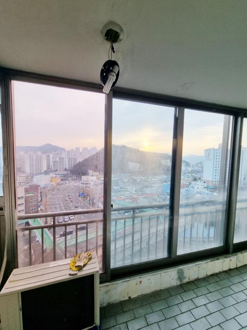 흰색 테이블과 노란 장갑이 놓인 발코니 창호 설치 과정