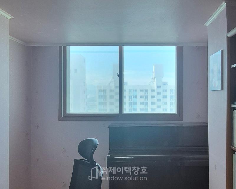 분홍색 벽면 중앙의 큰 창문과 검은색 가구