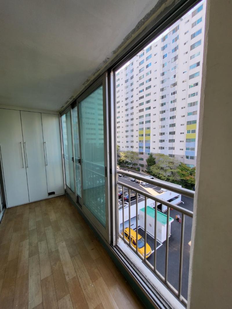 목재 바닥과 흰색 수납장이 배치된 발코니 공간