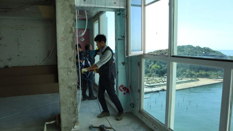 창문 근처에서 작업 중인 인력과 벽면의 케이블