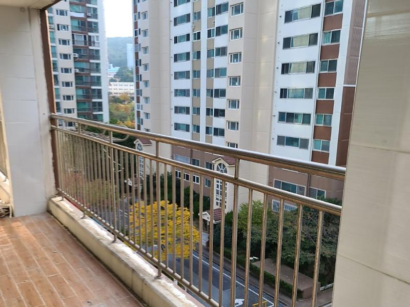 주변 건물과 도로가 보이는 발코니 난간 모습