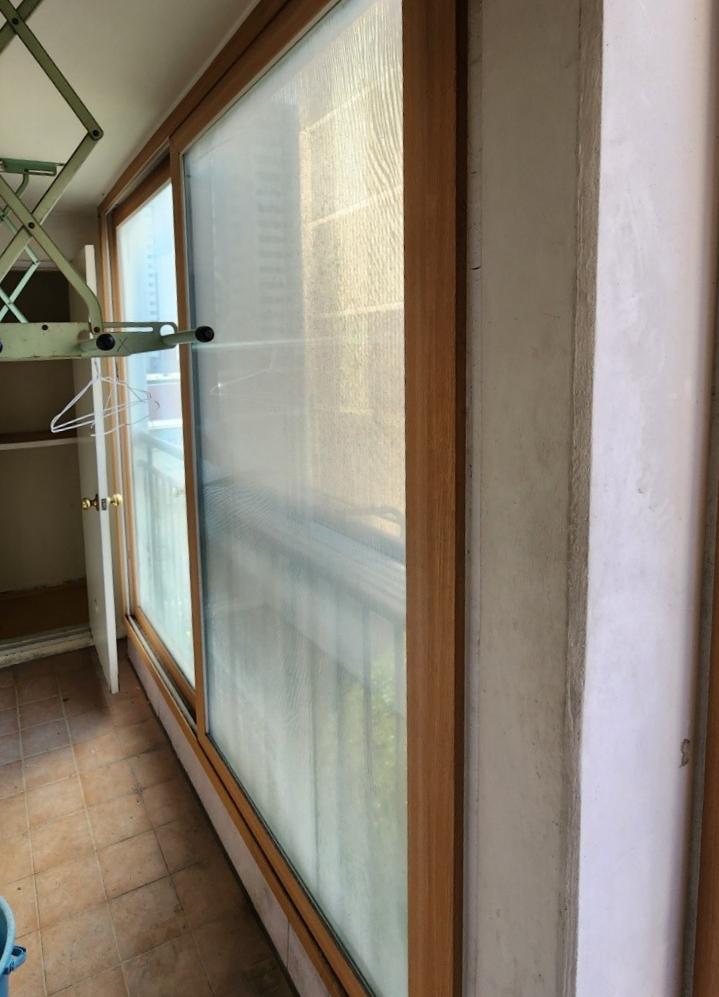 나무 프레임과 갈색 타일이 보이는 기존 발코니