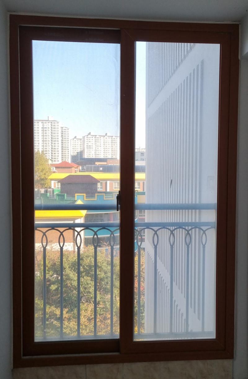 외부 건물과 나무가 배경으로 보이는 창호 프레임 근접 샷