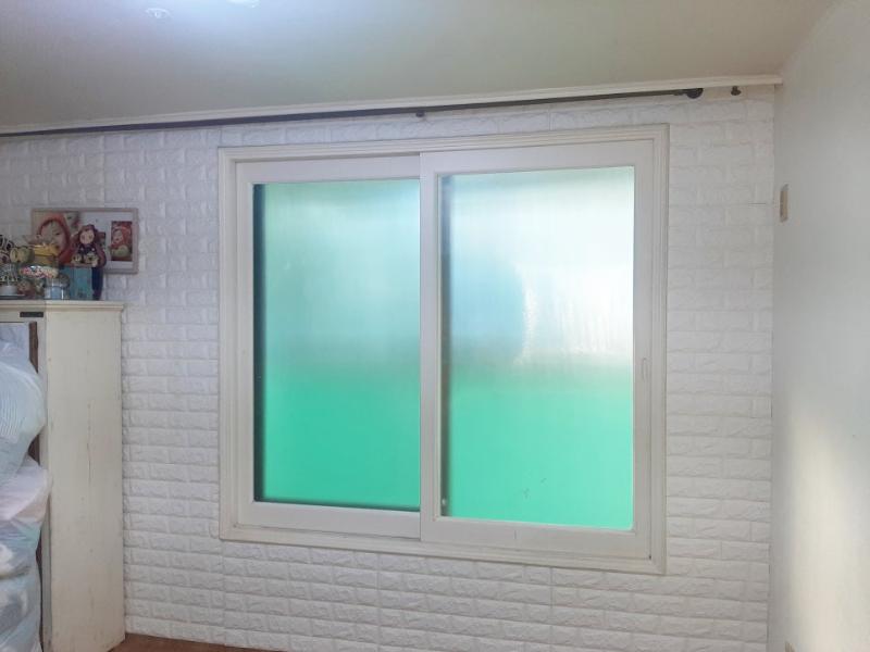 흰색 수납장 옆에 설치된 구형 슬라이딩 창호