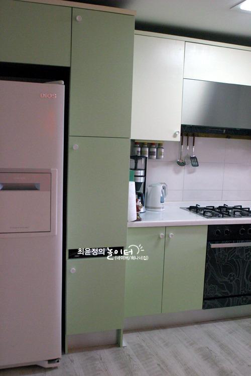녹색 하부장과 흰색 상판이 조화를 이룬 조리 공간