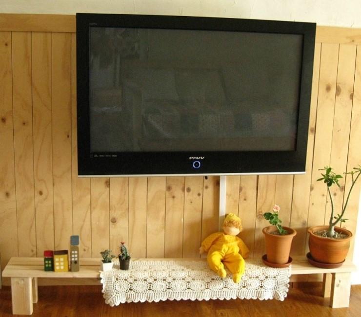 TV 아래 나무 선반과 목재 패널 벽면