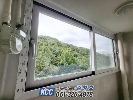 KCC 인증 표시가 부착된 창호와 외부 숲 배경