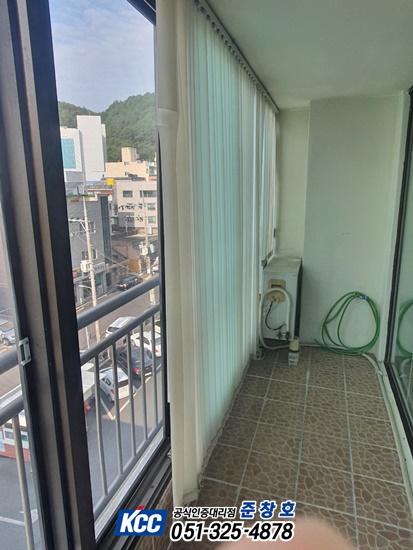 도시 풍경이 보이는 발코니의 타일 바닥과 커튼
