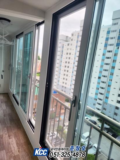 화이트 벽면과 나무 패턴 바닥이 보이는 발코니 창호 설치 모습