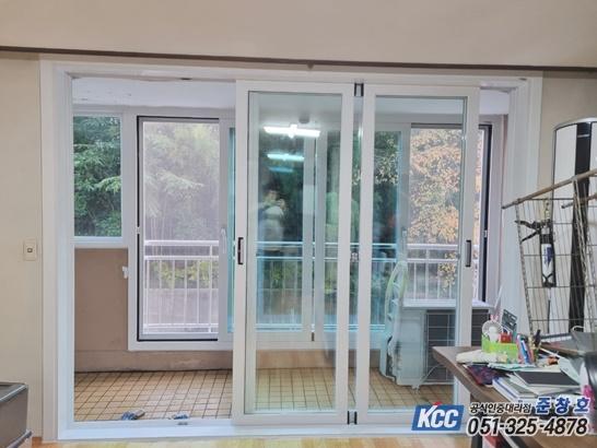 테라스 바닥과 외부 기기가 보이는 흰색 슬라이딩 창호