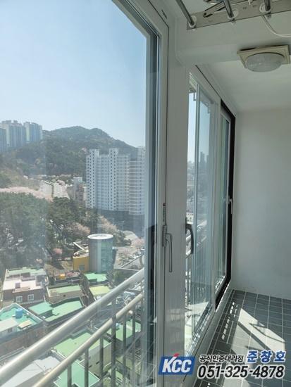 회색 타일 바닥과 투명 창호가 설치된 발코니 전경