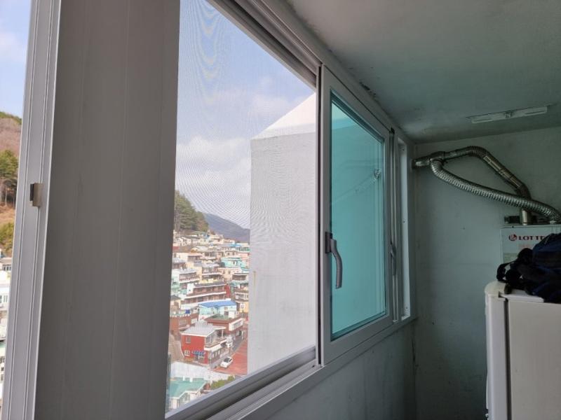 창문 프레임과 외부 풍경, 내부 금속 호스가 보이는 근접 샷
