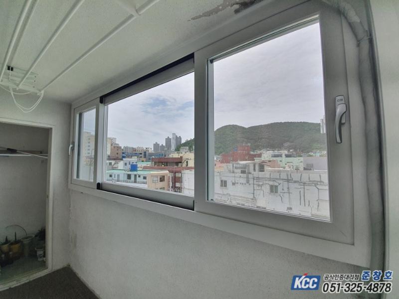 흰색 탄성코트 벽면과 회색 프레임 창호의 근접 모습