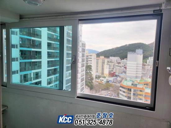 고층 건물과 산이 보이는 실내 창호 프레임 근접 샷
