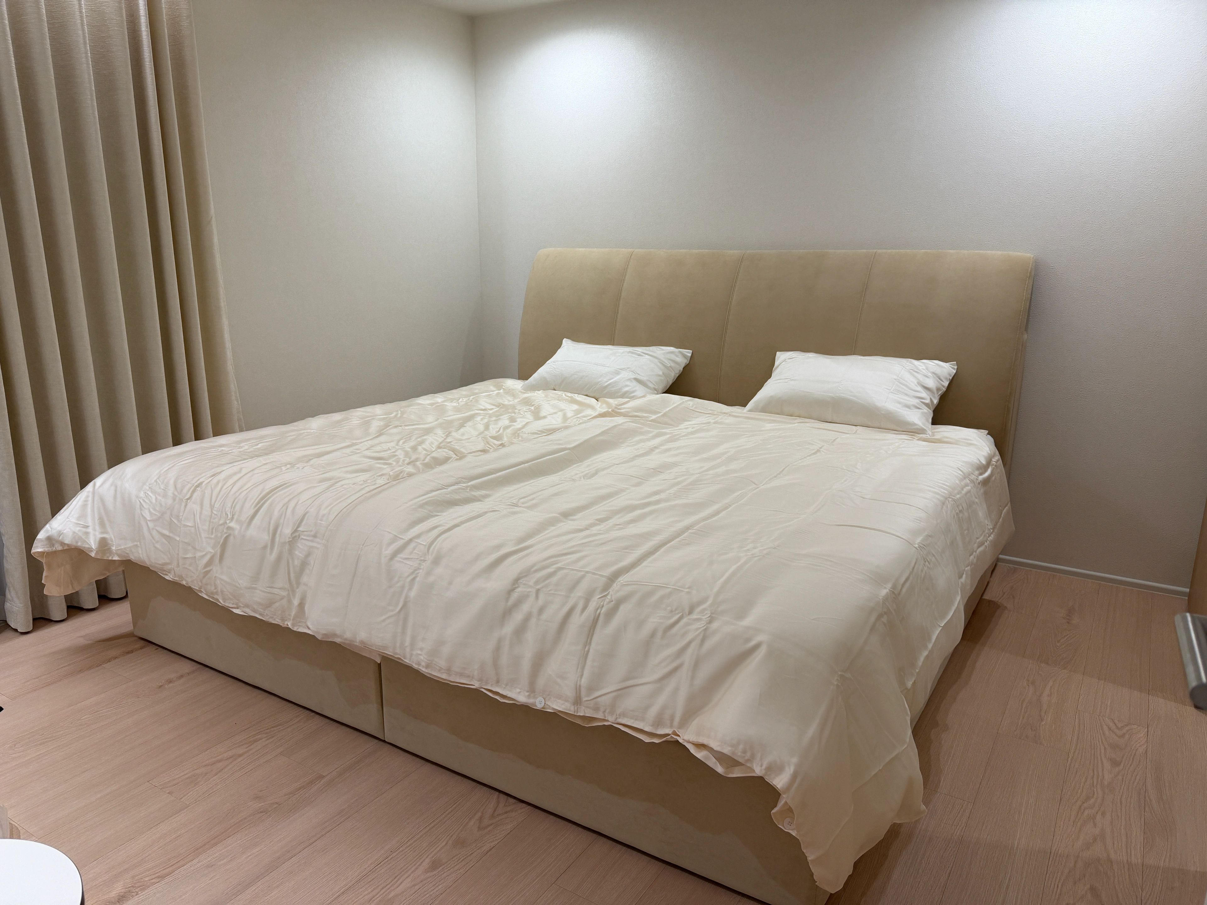 흰 침구 위로 이어지는 부드러운 빛.